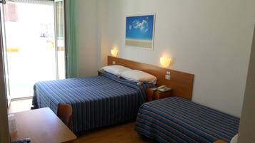 Ein Hotelzimmer mit zwei Betten, einem Schreibtisch und einem Stuhl.