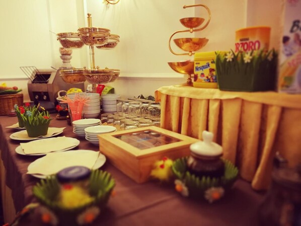 Una mesa dispuesta con platos, vasos y un centro de mesa decorativo.