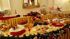 A buffet table with various food items, including fruits, pastries, and a cake. - Hotel Royal (Bolsena)