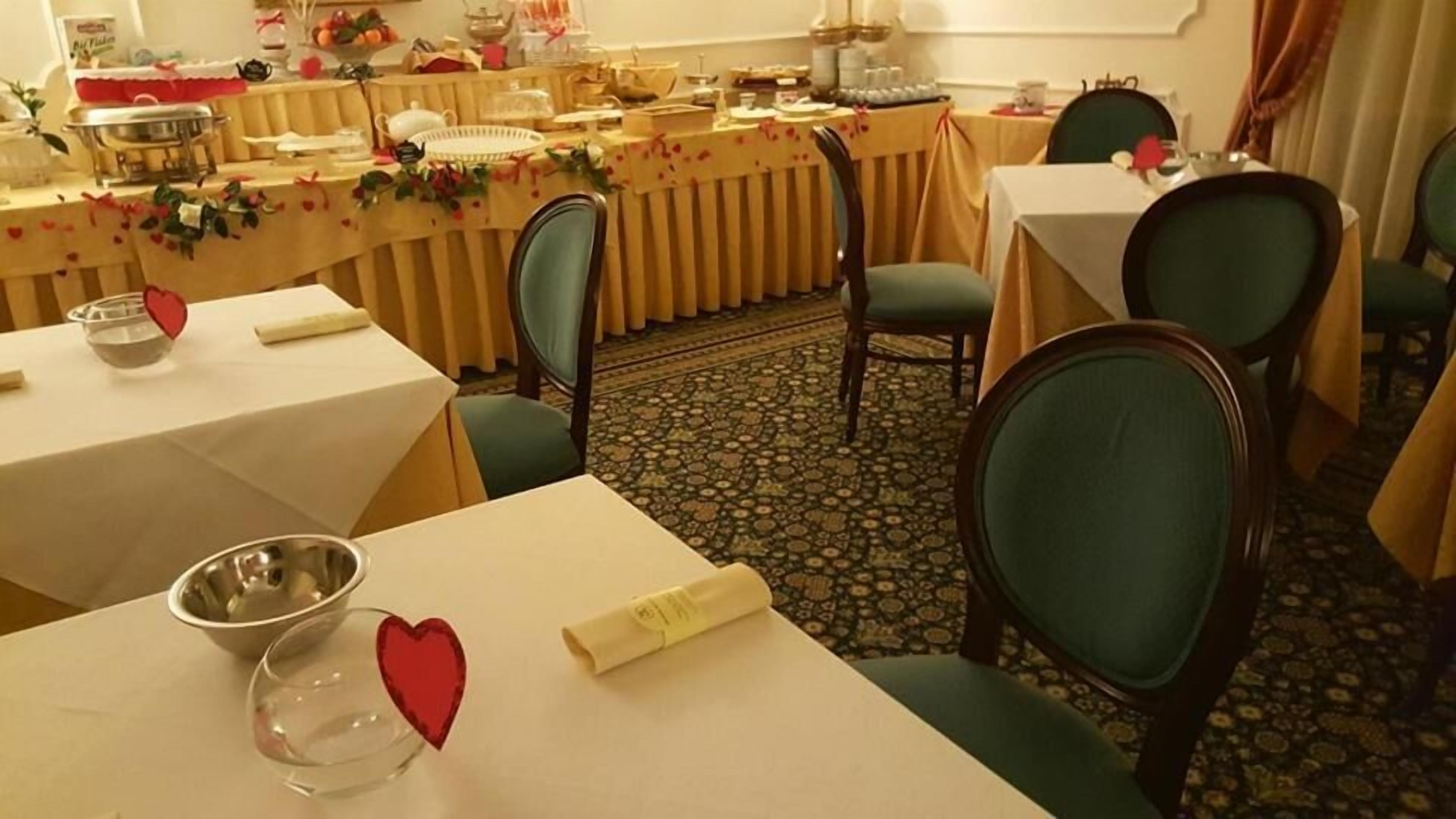 A dining area with tables set for a meal, chairs, and a carpeted floor.