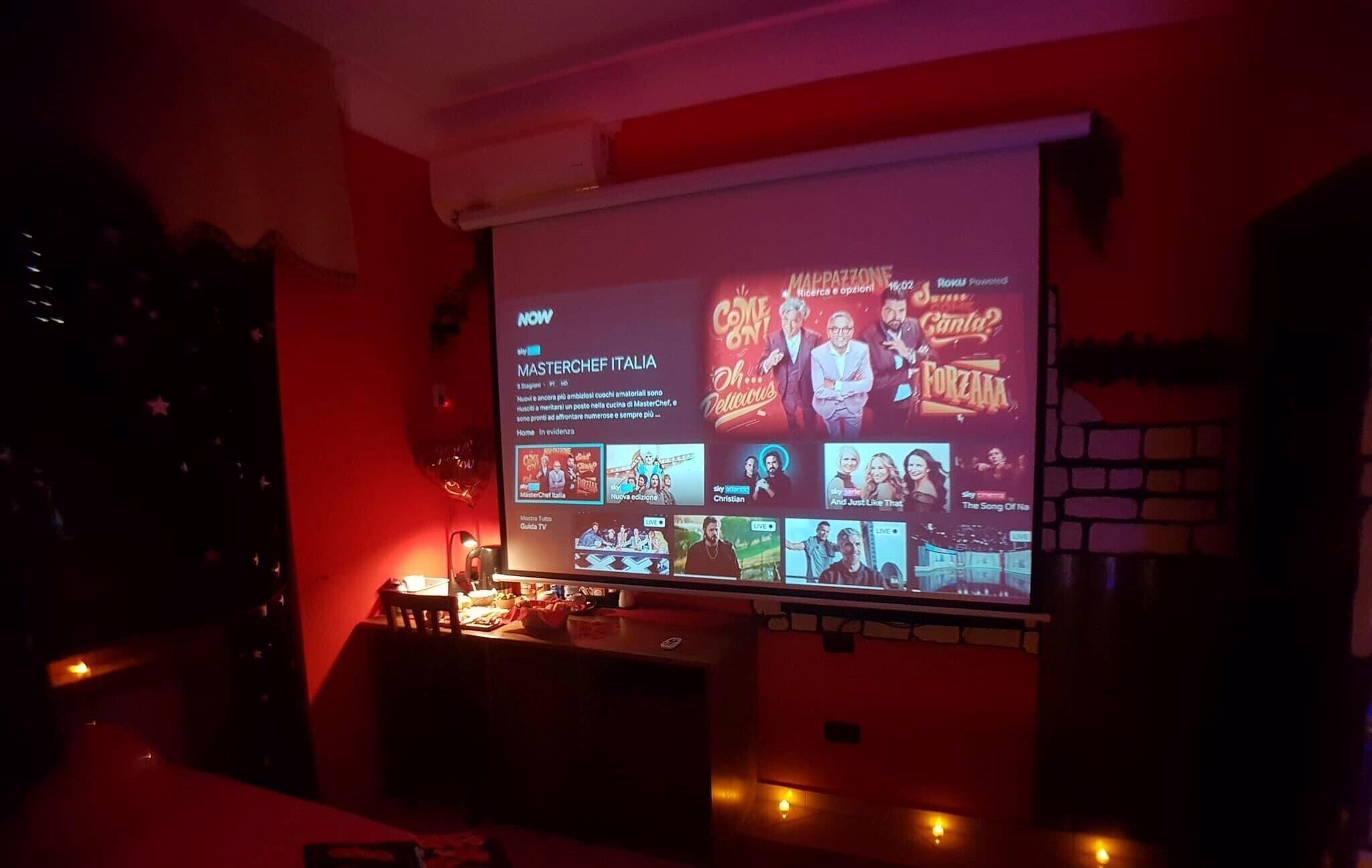 Sistema de cine en casa con una pantalla grande mostrando el menú de televisión.