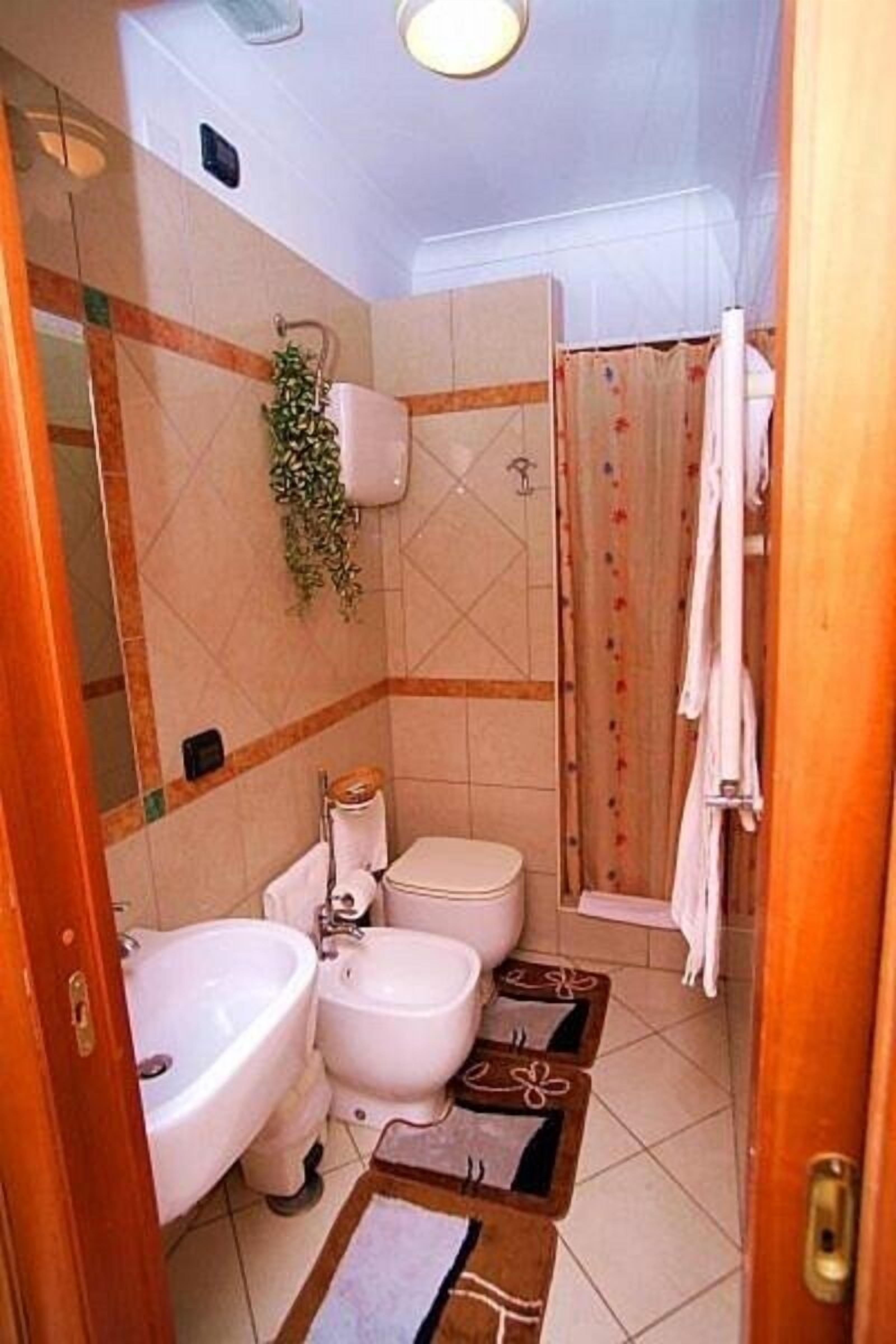A bathroom with a toilet, bidet, and sink.