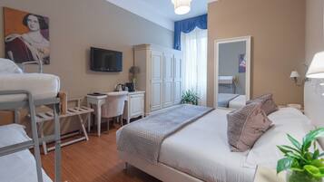 A hotel room with a bed, desk, chair, and a television.