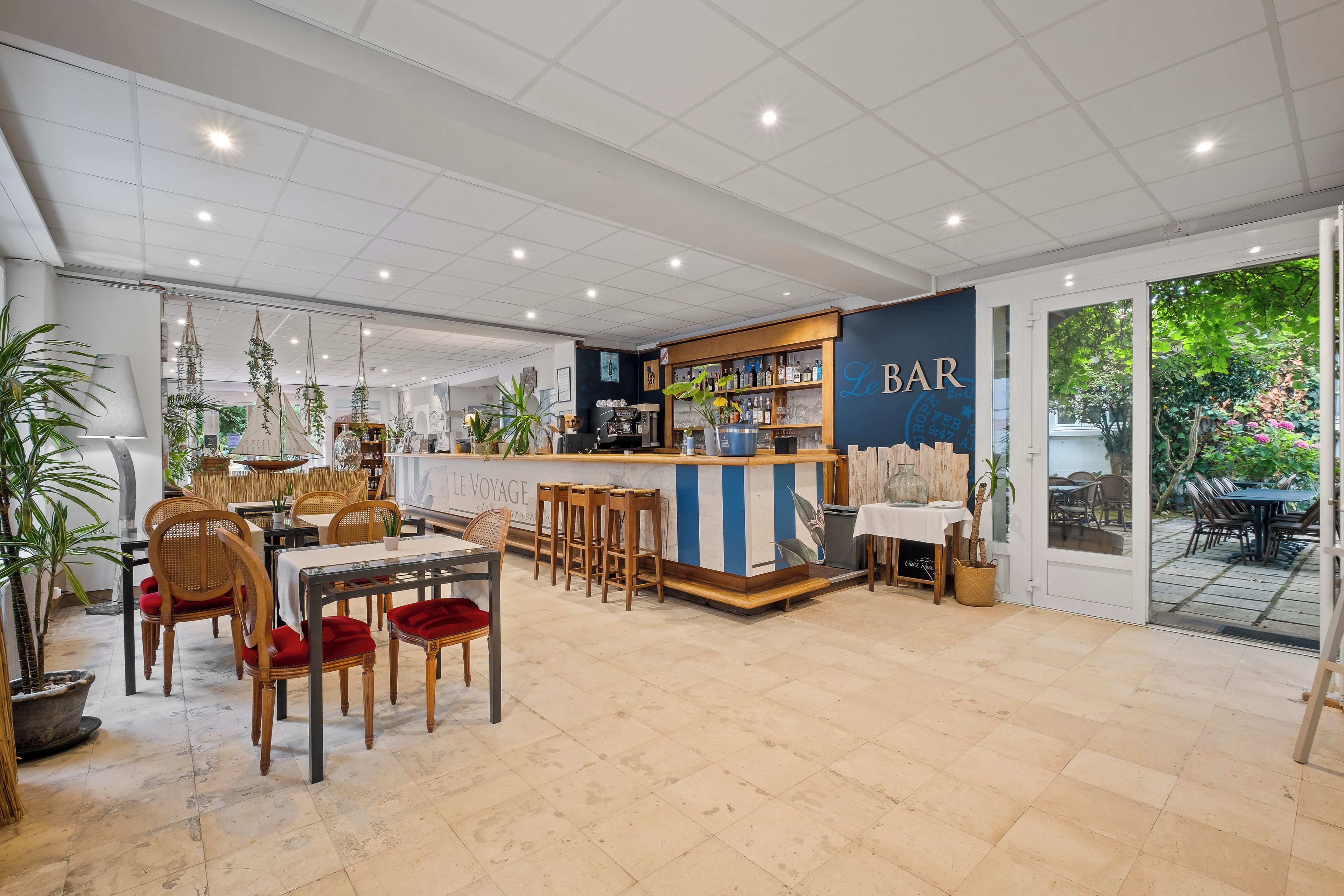 Un espace bar avec un comptoir, des sièges et une vue sur l’extérieur.