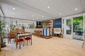 A bar area with a counter, seating, and a view of the outdoors.