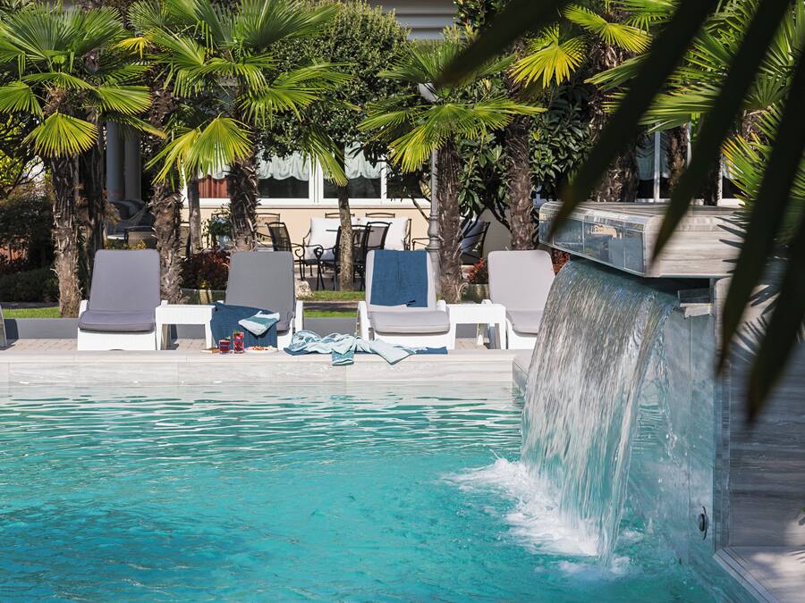 A pool area with lounge chairs and a water feature.