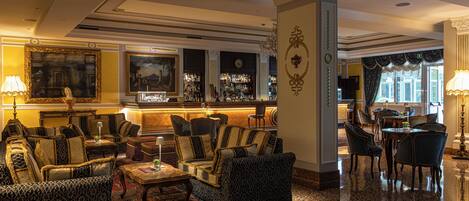 A spacious lobby with a bar area, comfortable seating, and a decorative rug.