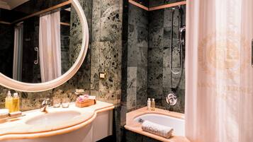 A bathroom with a large mirror, a bathtub, and a shower area.