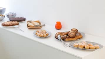 Et udvalg af kager og desserter på et hvidt bord.