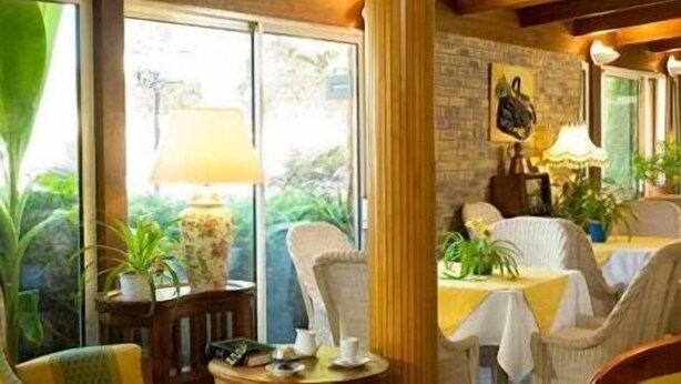 A room with a large window, a round table, and two chairs. - LOGIS Chez Bach (Chaussin)