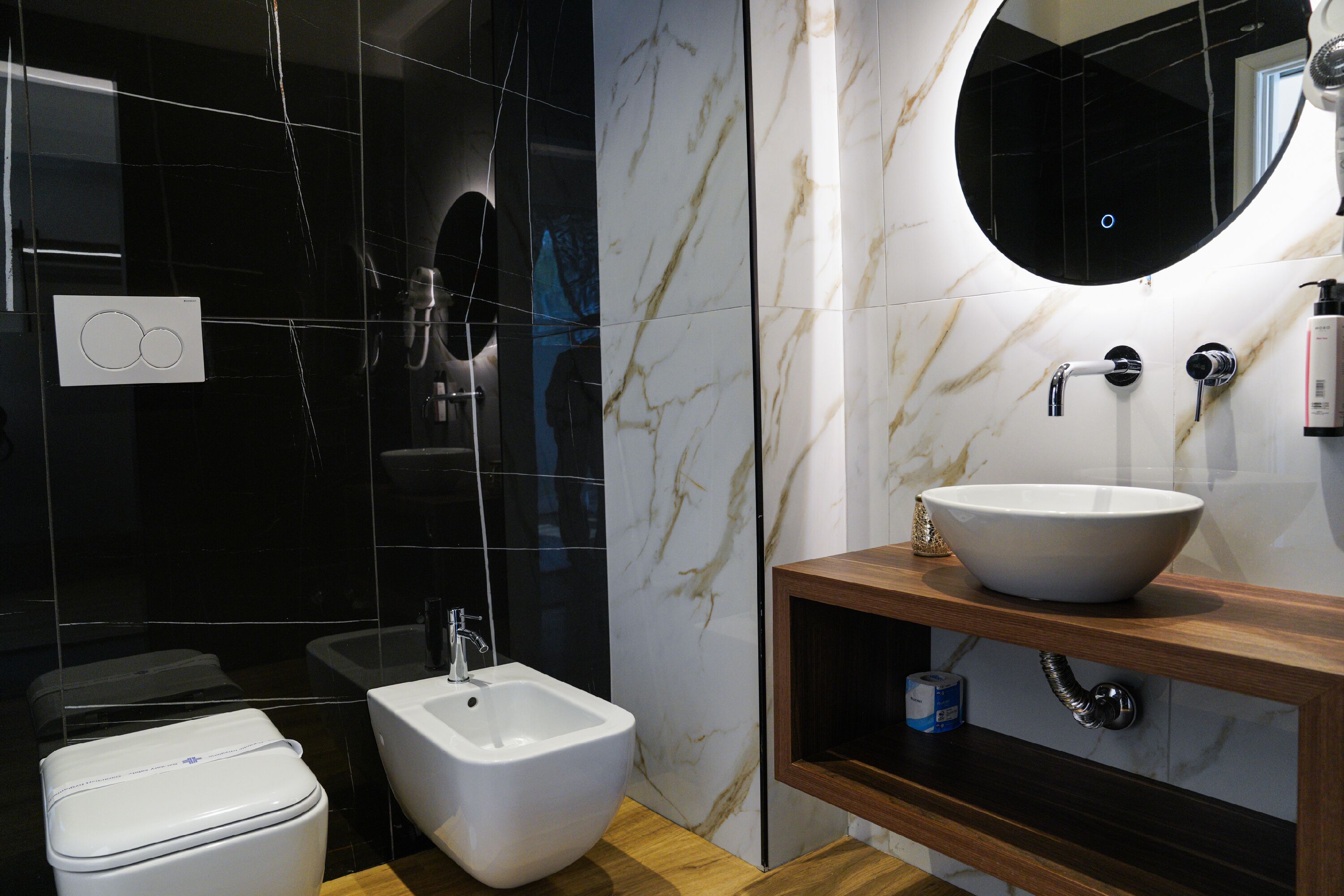 Ein modernes Badezimmer mit einer Bidet-Funktion, einem Waschbecken und einem Spiegel.