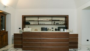 A modern kitchen with a wooden counter, marble floor, and various kitchen appliances and storage cabinets. - Hotel Il Tesoro Pompeiano (Pompei)