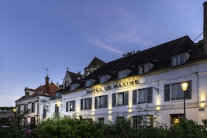 A historic building with a sign reading "HOTEL LE MAXIME".