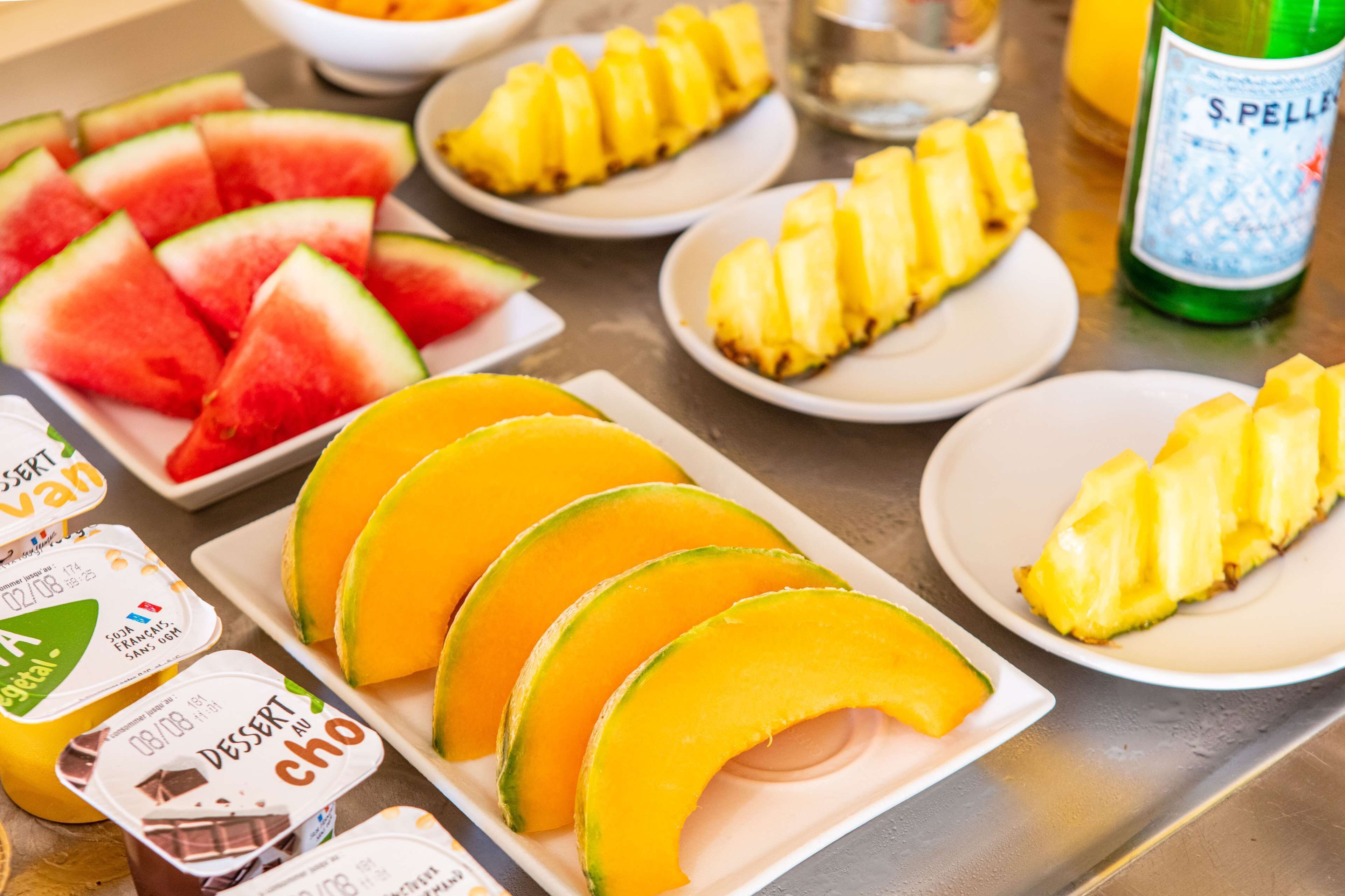 Een tafel met verschillende soorten fruit en dessertbekers.
