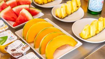 Una mesa con frutas diversas y recipientes para postres.
