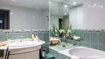 A modern bathroom with two sinks, a bathtub, and a large mirror.