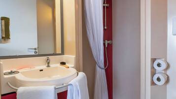 Een badkamer met een wastafel, spiegel, douche en toilet.