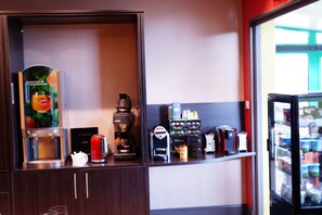 A coffee station with a coffee maker, a red kettle, a coffee grinder, and a coffee machine. - Citotel Du Port Rhu (Douarnenez)