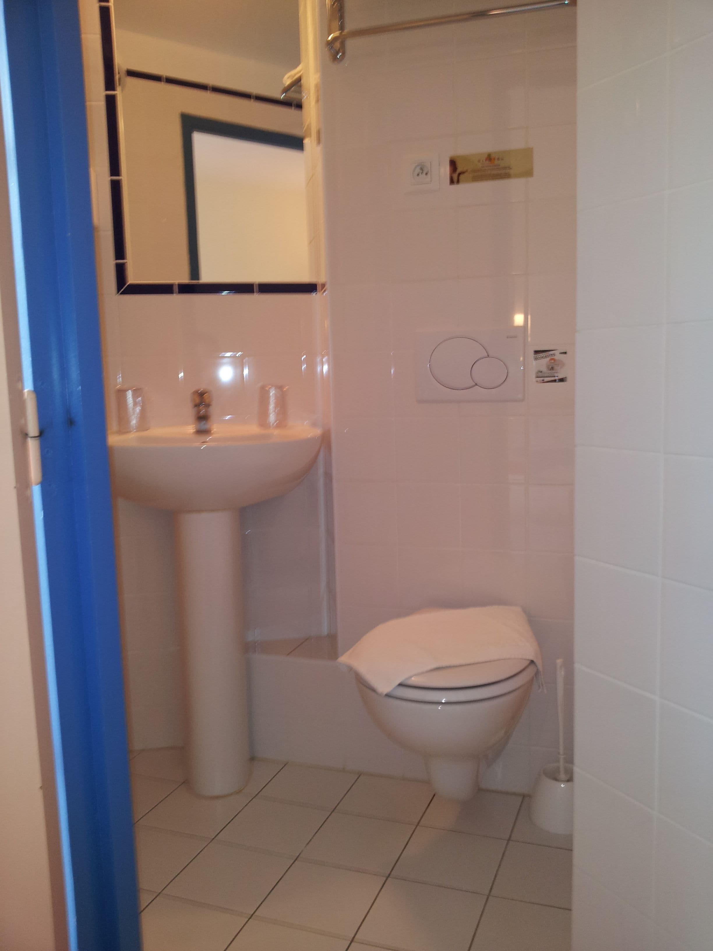 Une salle de bain avec un lavabo, des toilettes et un miroir.