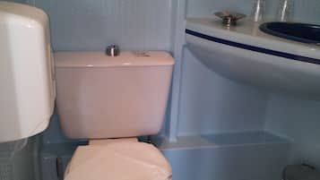Un baño con inodoro, lavamanos y secamanos.