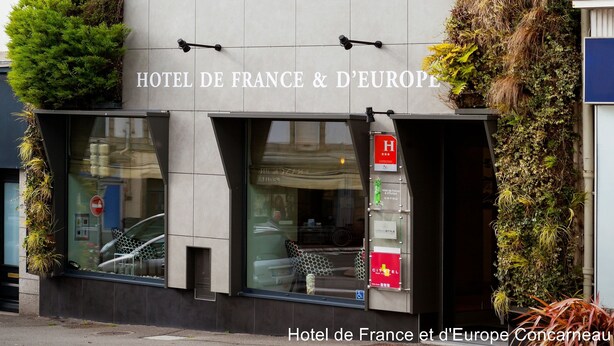 Een modern hotelgevel met de naam "HOTEL DE FRANCE" en "HOTEL DE FRANCE & D'EUROPE" in opvallende letters.