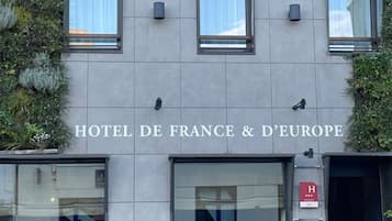 L’extérieur de l’HÔTEL DE FRANCE & DE EUROPE se distingue par sa façade moderne, dotée de grandes fenêtres et d’un design minimaliste.