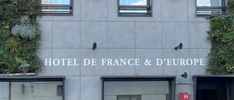 Het uiterlijk van HOTEL DE FRANCE & DE EUROPE, met een moderne gevel, grote ramen en een minimalistisch design.