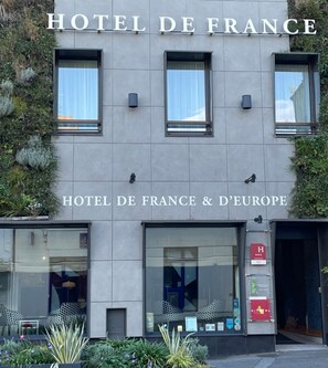 Het uiterlijk van HOTEL DE FRANCE & DE EUROPE, met een moderne gevel, grote ramen en een minimalistisch design.