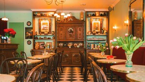 A dining area with checkered flooring, wooden chairs, and tables.