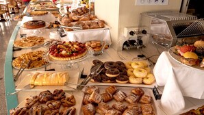 Um buffet com diversos doces, bolos e sobremesas.