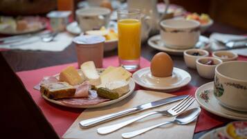A breakfast setting with various food items and utensils on a table.