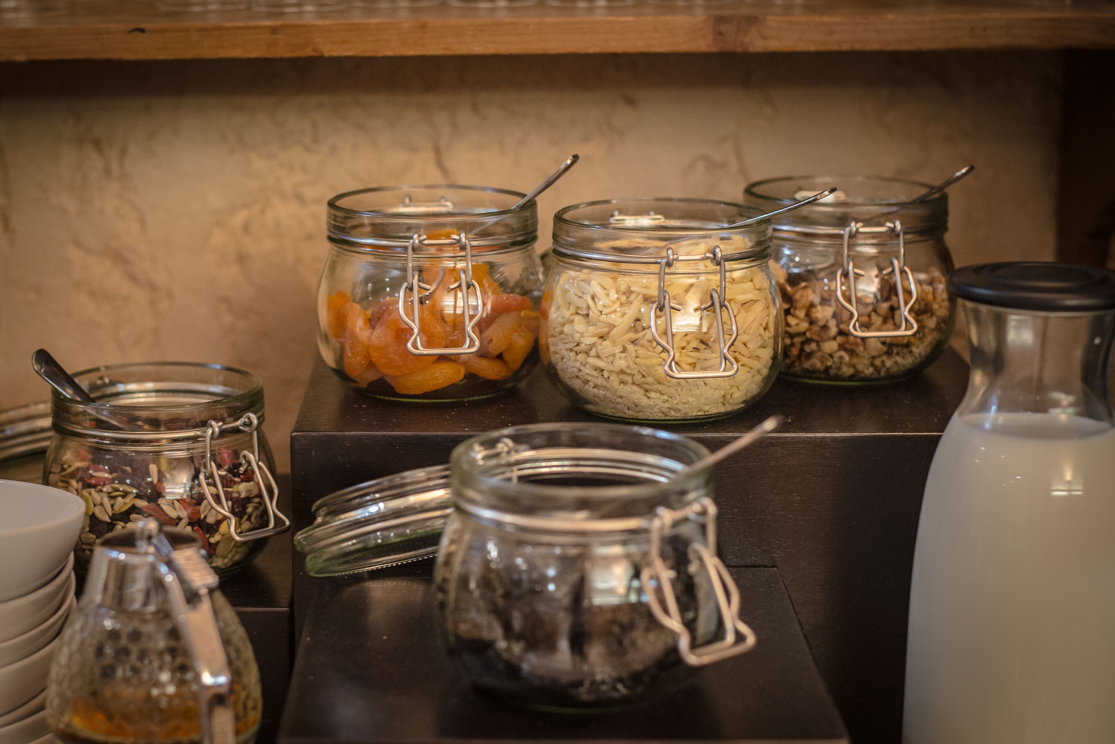 A kitchen counter with various food items in jars, including dried fruits and nuts.