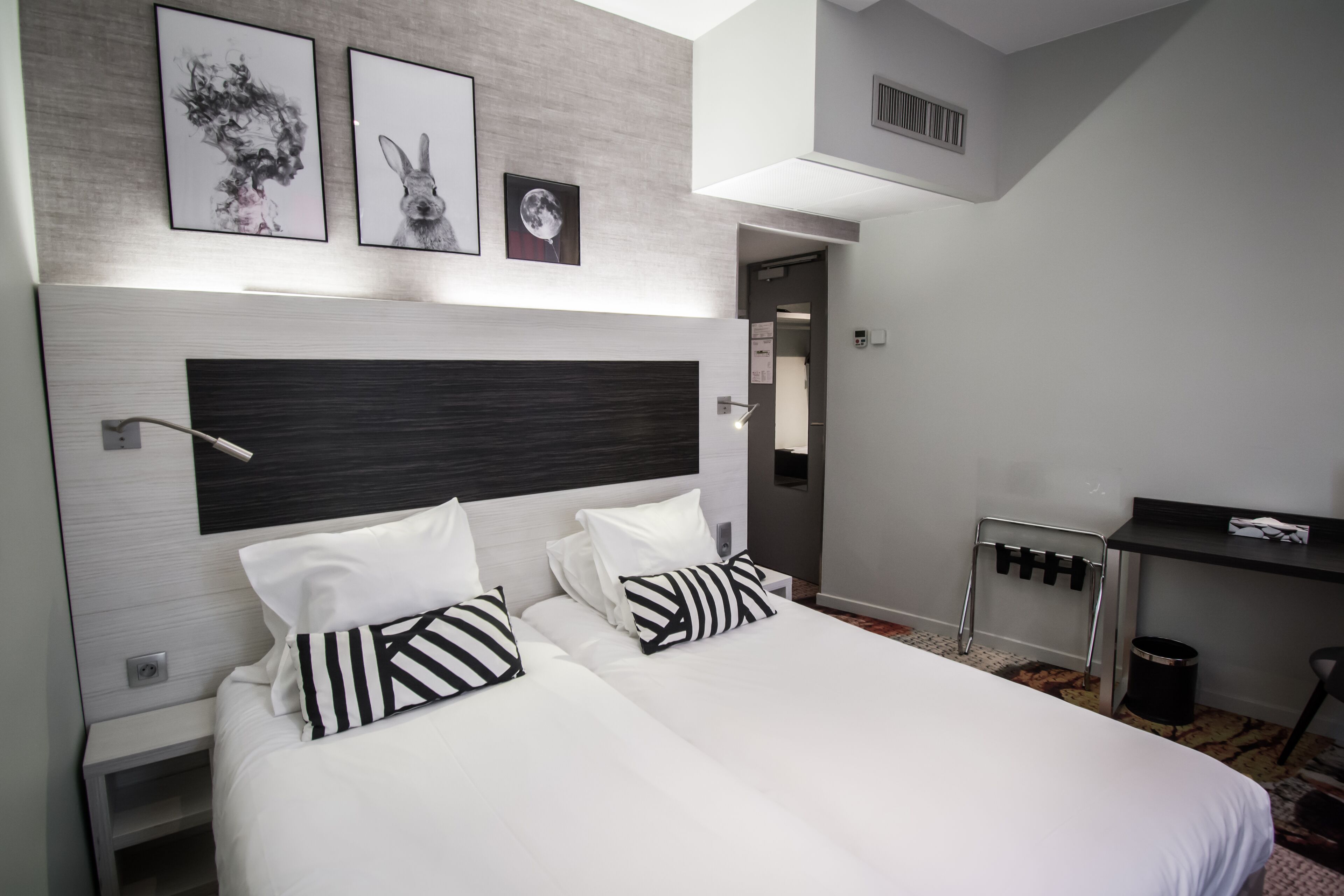 Ein modernes Hotelzimmer mit einem großen Bett, einem Schreibtisch und einem Spiegel.