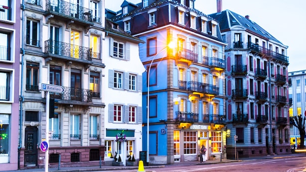 Un edificio de varios pisos con un restaurante en la planta baja llamado "Nuit Farce".