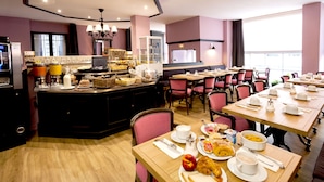 Un bufé de desayuno con diferentes opciones de comida y disposición de mesas.