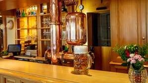 A bar area with copper equipment, a beer mug, and a vase with flowers. - Best Western Plus Au Cheval Blanc Mulhouse Nord (Baldersheim)