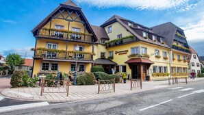 A yellow building with a balcony, a sign that reads 'Hotel', and a street in front. - Best Western Plus Au Cheval Blanc Mulhouse Nord (Baldersheim)