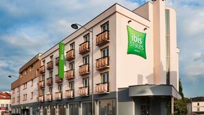 Un hôtel à plusieurs étages doté de balcons, d’une enseigne verte « ibis Styles Hotels » et d’une façade moderne.