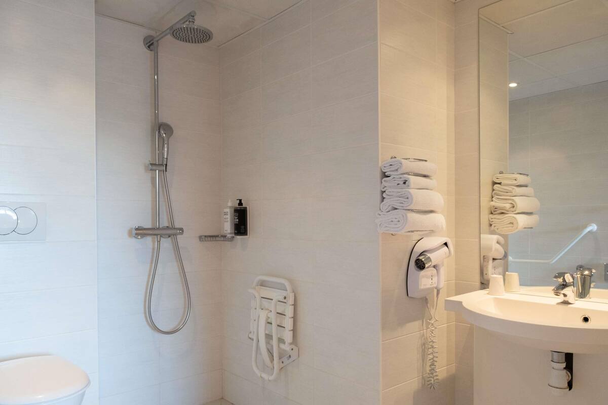 Un baño moderno con ducha, inodoro y lavabo.
