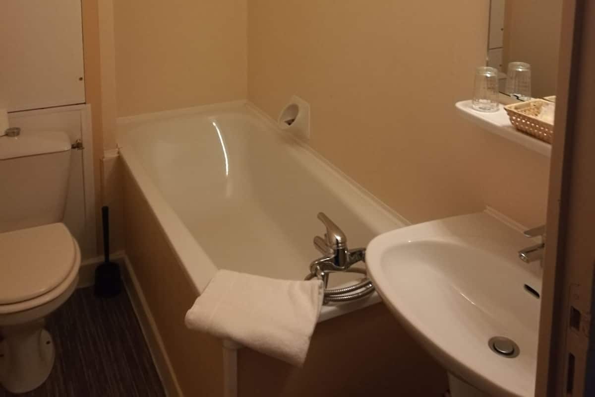 A bathroom with a bathtub, toilet, and sink.