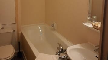 Un baño con bañera, inodoro y lavamanos.