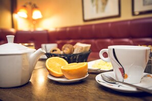 A breakfast setting with a teapot, orange slices, and a cup on a table. - Hotel de la Paix Lille (Lille)