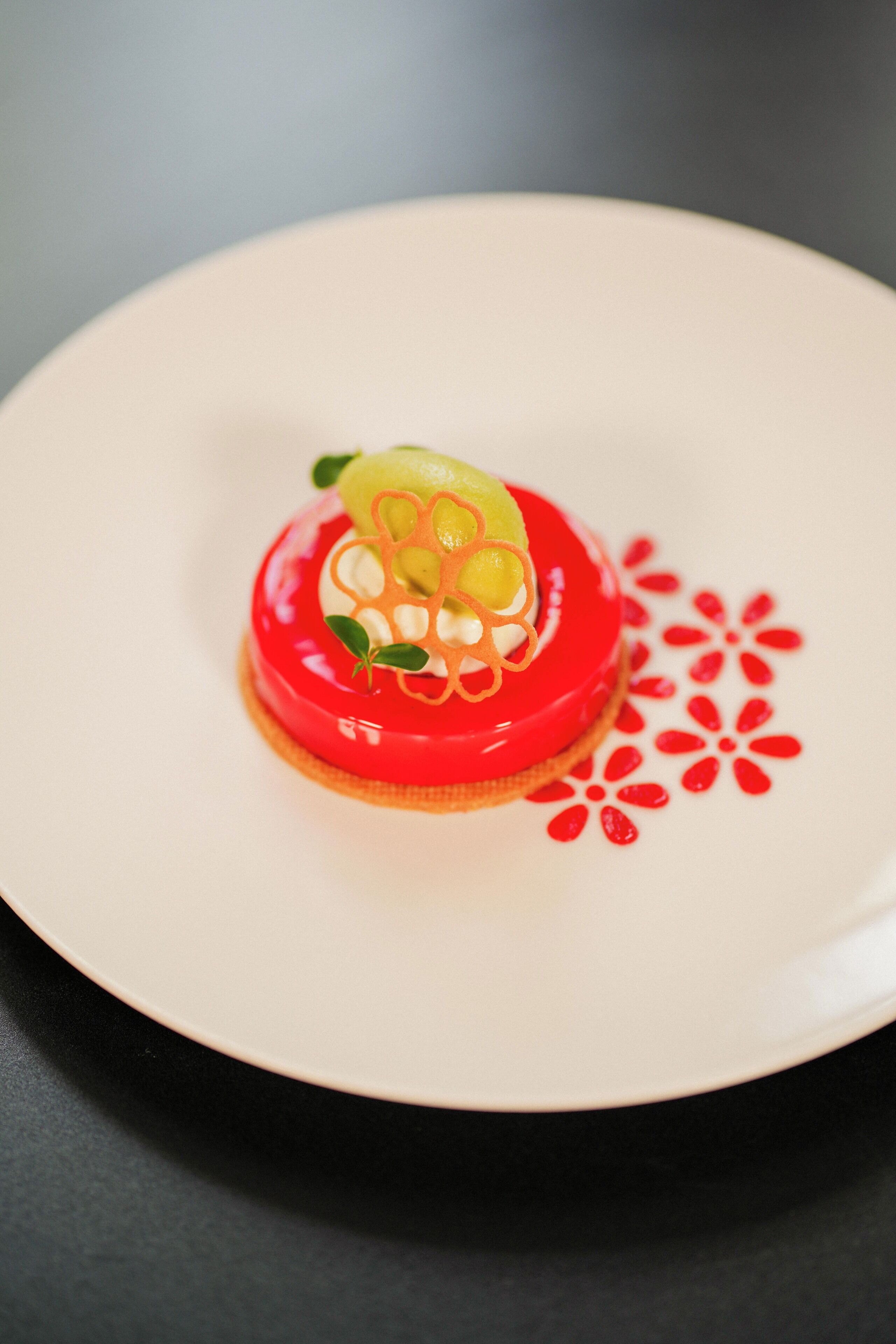 Un dessert servi dans une assiette ornée d’un motif rouge.