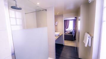 Een moderne badkamer met een glazen douchecabine, een wastafel en een handdoekhouder.