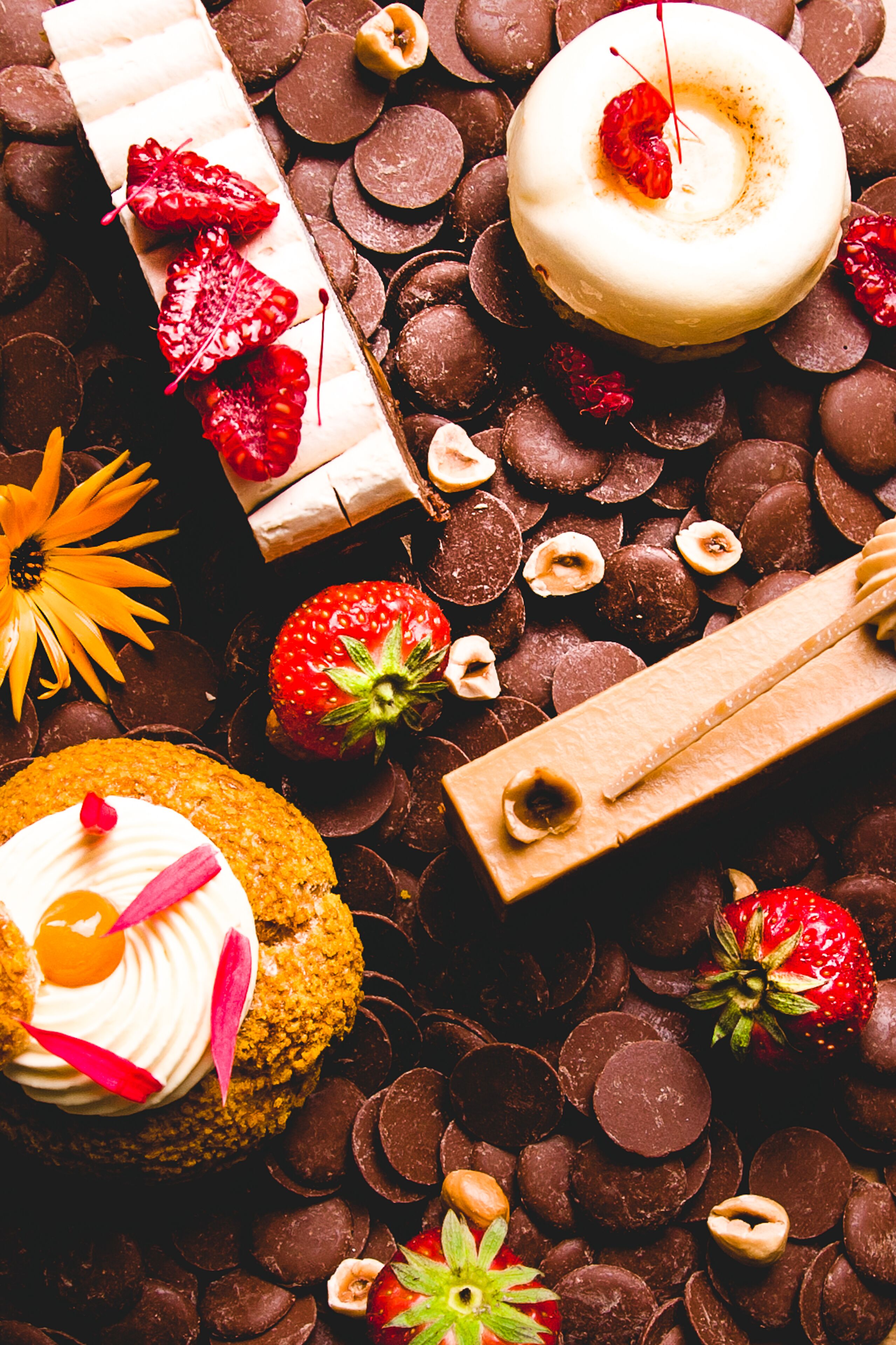Diversas opciones de postres, entre ellas un pastel cubierto de chocolate, un pastel blanco con glaseado y una cereza, y un pastel con fruta encima.