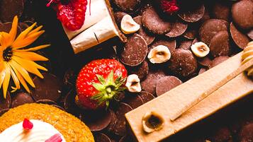 Diversas opciones de postres, entre ellas un pastel cubierto de chocolate, un pastel blanco con glaseado y una cereza, y un pastel con fruta encima.