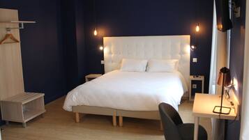 Un dormitorio moderno con una cama grande, mesitas de noche, un escritorio y una silla.