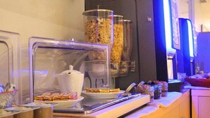 A breakfast buffet with various food items and containers. - Hôtel Le Moderne (Toulouse)