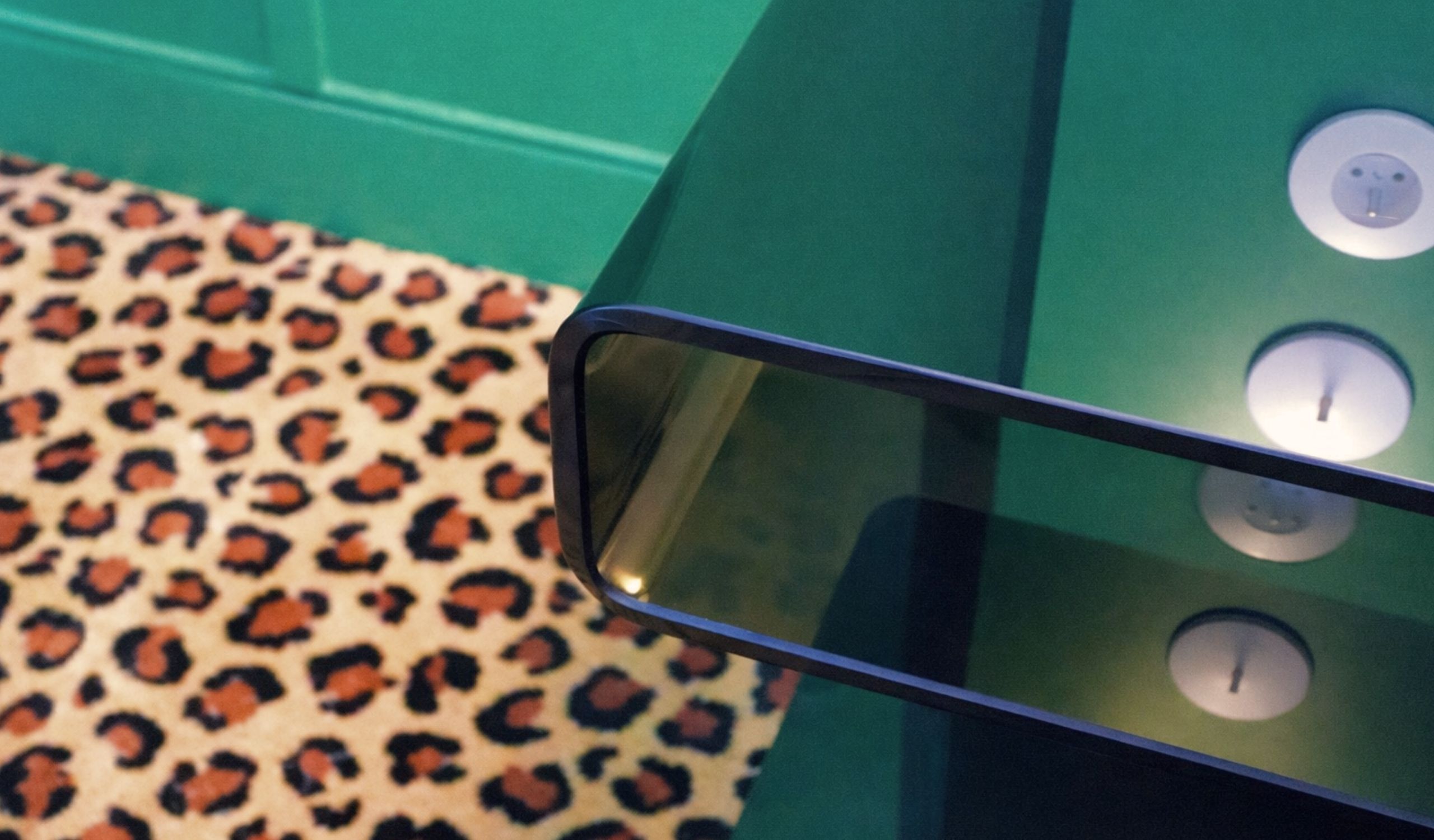 A green table with a reflective surface and a leopard print tablecloth.