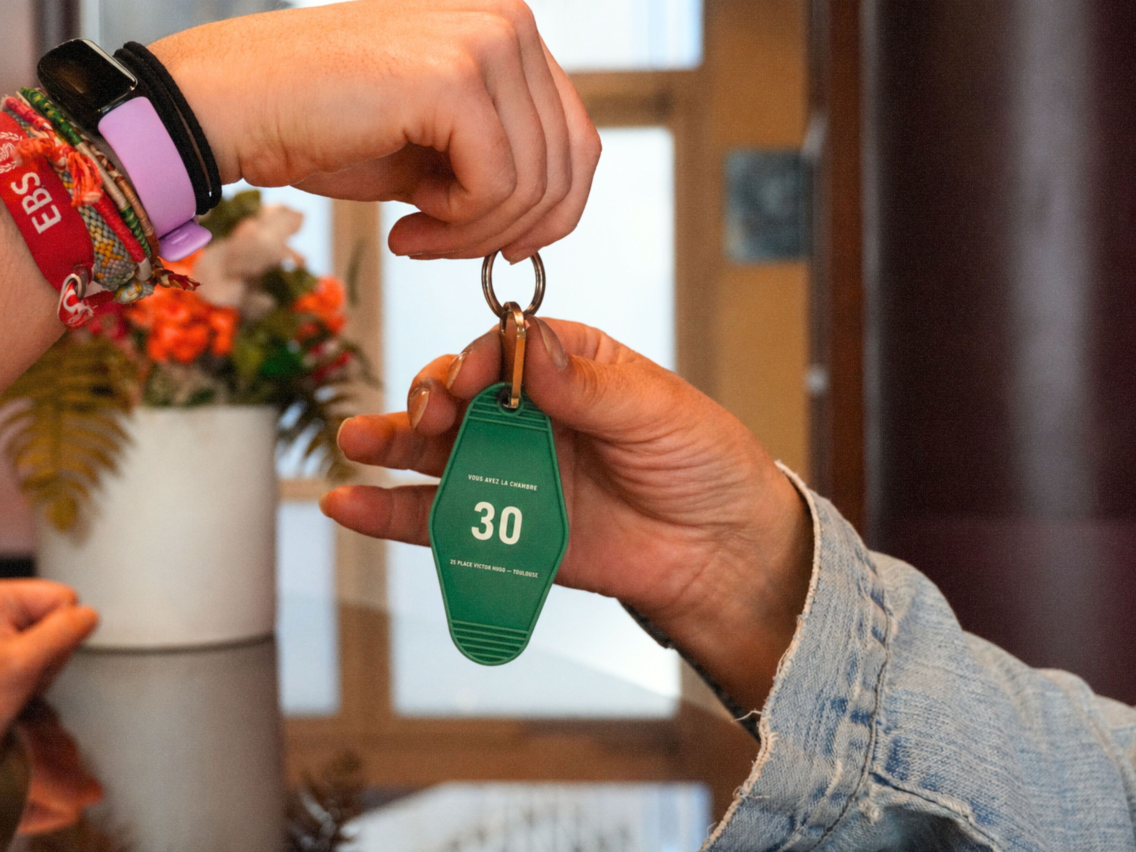 A hand holding a keychain with the number 30.